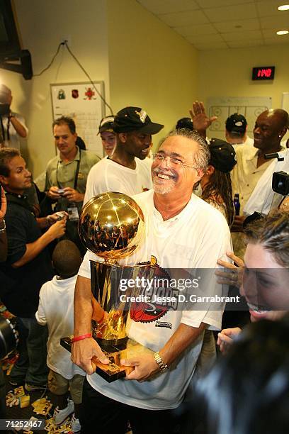 Tean owner Micky Arison of the Miami Heat celebrates with the Larry O'Brien trophy in the locker room after they won the NBA Championship with their...