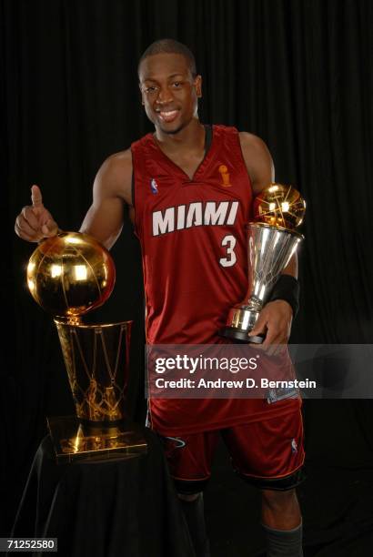 Dwyane Wade of the Miami Heat poses for a portrait with the Larry O'Brien Championship trophy and the MVP trophy after their Game Six victory of the...