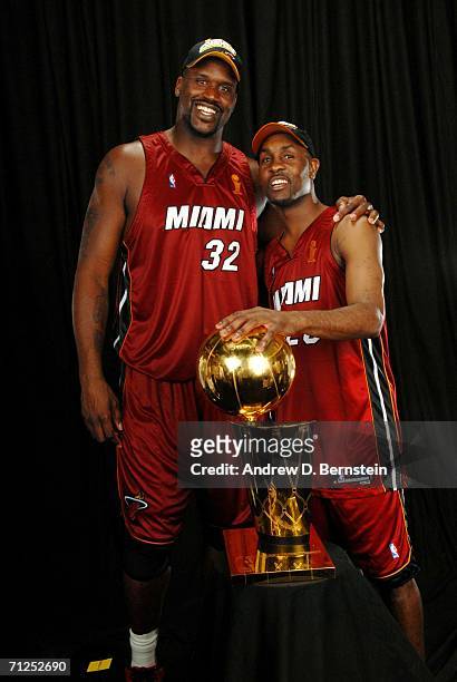 Shaquille O'Neal and Gary Payton of the Miami Heat pose for a portrait with the Larry O'Brien Championship trophy after their 95-92 Game Six victory...