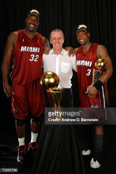 Shaquille O'Neal#32, head coach Pat Riley and Dwyane Wade#3 of the Miami Heat poses for a portrait with the Larry O'Brien Championship trophy after...