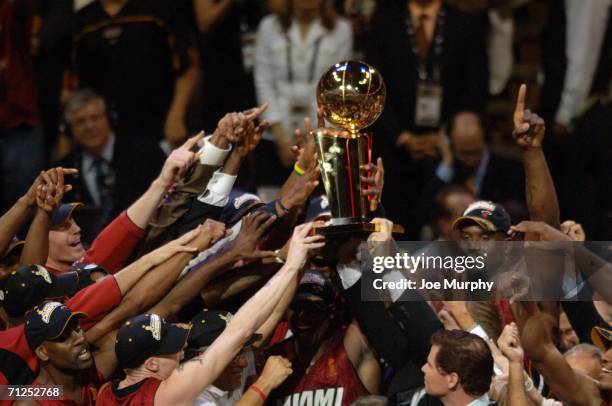 The Miami Heat celebrates after winning the NBA Championship by holding the Larry O'Brien trophy in Game Six of the 2006 NBA Finals on June 20, 2006...