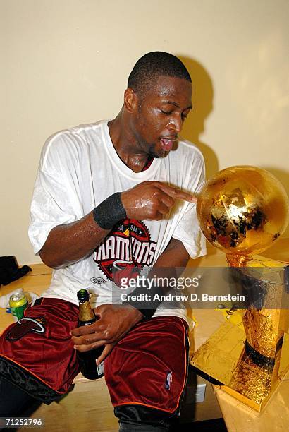 Dwyane Wade of the Miami Heat celebrates with the Larry O'Brien Championship trophy after their 95-92 Game Six victory of the 2006 NBA Finals against...