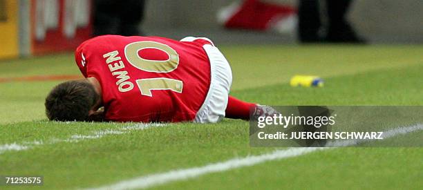 English forward Michael Owen lies on the pitch after badly injuring his right knee uring the opening round Group B World Cup football match Sweden...