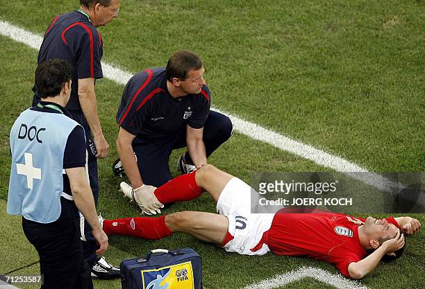 English forward Michael Owen is treated on the pitch after badly injuring his right knee uring the opening round Group B World Cup football match...