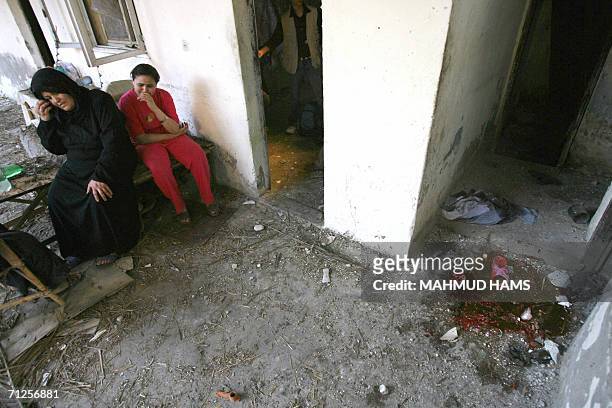 Palestinian woman and girl sit close to where a woman was killed in a home hit during an Israeli missile strike in Khan Yunis in the southern Gaza...