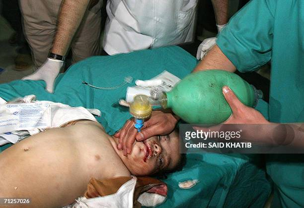 An injured toddler is rushed into the Naser hospital in the southern Gaza Strip town of Khan Yunis 21 June 2006, following an Israeli air strike, the...