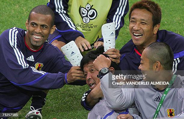 Japanese players Alessandro Santos and goalkeeper Yoichi Doi jest with physical trainer Takeshi Satouchi, 21 June 2006, in Dortmund, Germany. Japan's...