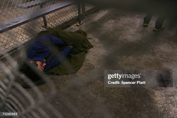 Man who was caught crossing the U.S. Border with Mexico illegally sleeps in a holding cell June 21, 2006 at the U.S. Border Patrol processing center...