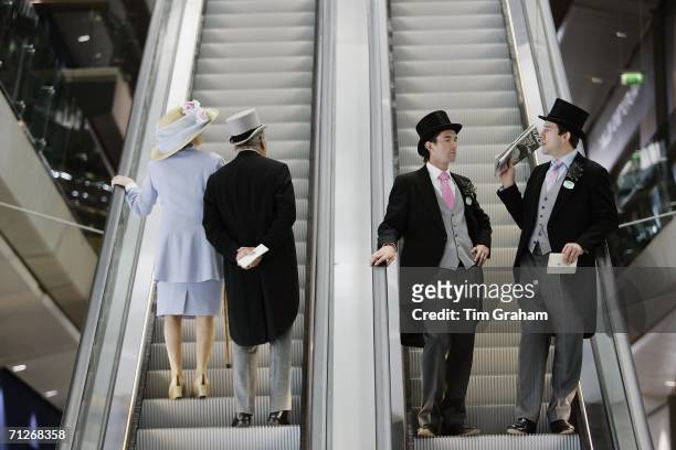 Racegoers wearing traditional Ascot fashions travel on the escalators inside the newly refurbished Ascot Grandstand on Ladies' Day At Royal Ascot...