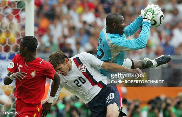 Ghanaian goalkeeper Richard Kingston makes a save as US forward Brian McBride clashes with Ghanaian defender John Mensah in the opening round Group E...