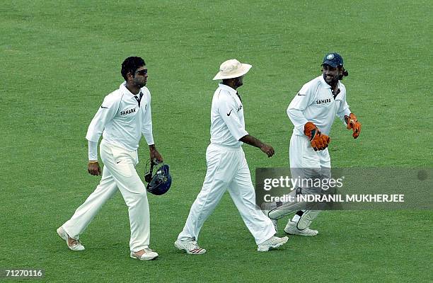 Indian cricketers Yuvraj Singh, Virender Sehwag and Mahendra Singh Dhoni run back to the dressing room as rain interrupts play on the first day of...