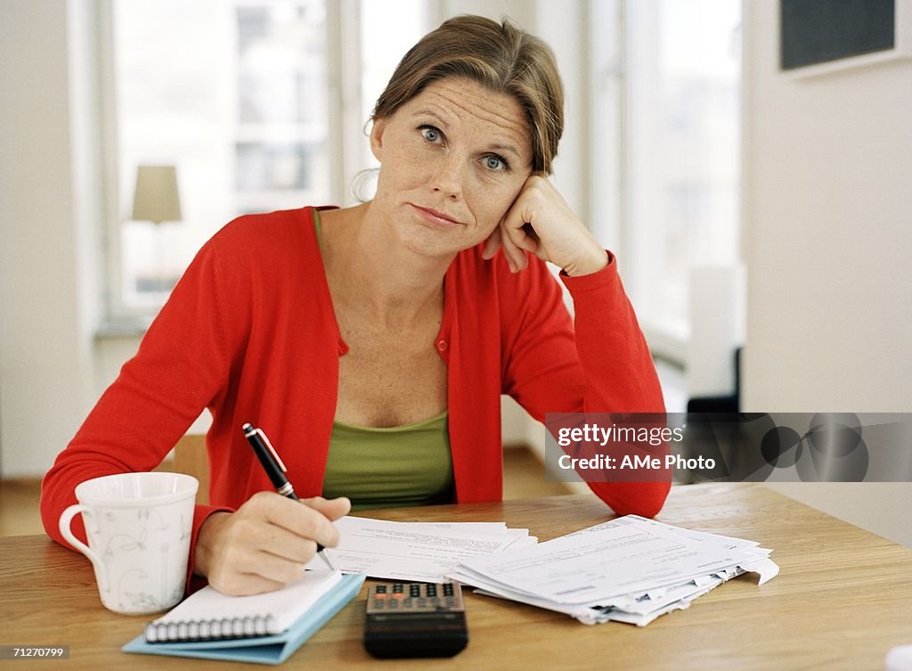 A woman sitting by a table.