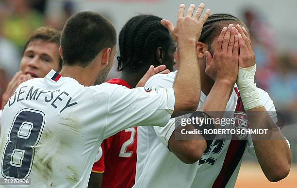 Defender Oguchi Onyewu reacts with US midfielder Clint Dempsey and US forward Brian McBride after a missed shot at goal during the opening round...