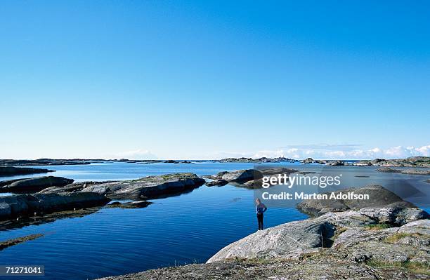 a person on a cliff. - archipelago stockfoto's en -beelden