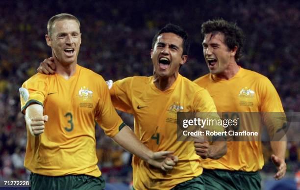 Craig Moore of Australia celebrates with teammates Tim Cahill and Harry Kewell , after taking a penalty to level the scores at 1-1 during the FIFA...