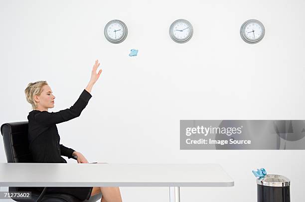 businesswoman throwing paper into bin - clock person desk stock pictures, royalty-free photos & images