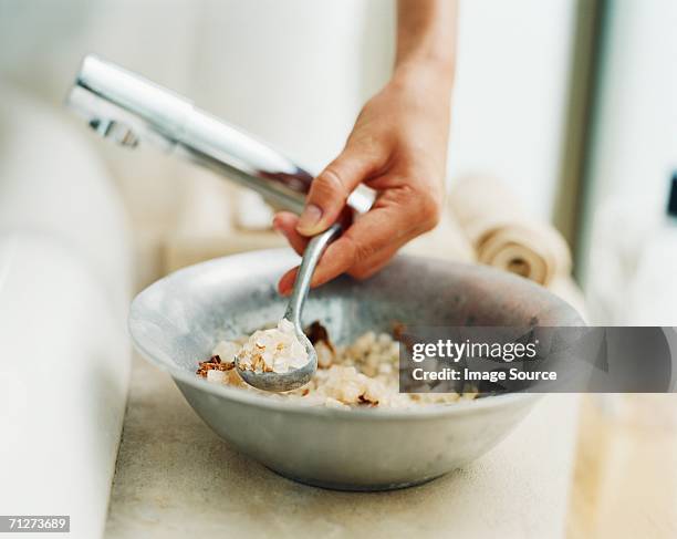 young woman spooning out bath salts - bath salt stock pictures, royalty-free photos & images