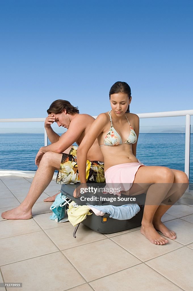 Stressed couple with suitcase