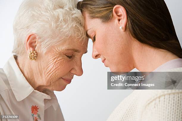 mother and daughter - forehead stock-fotos und bilder