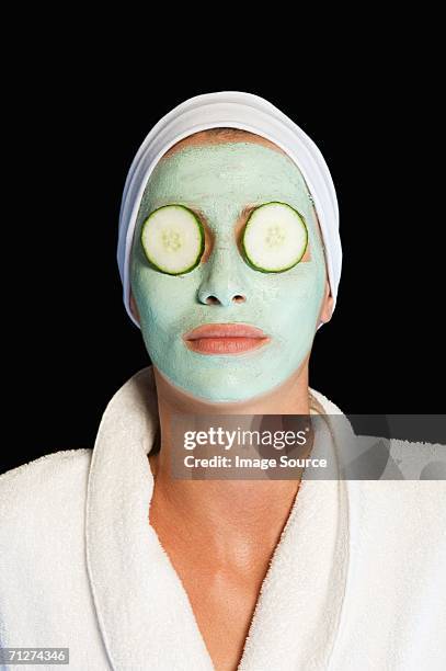 woman wearing facial mask and cucumber slices - gurke stock-fotos und bilder