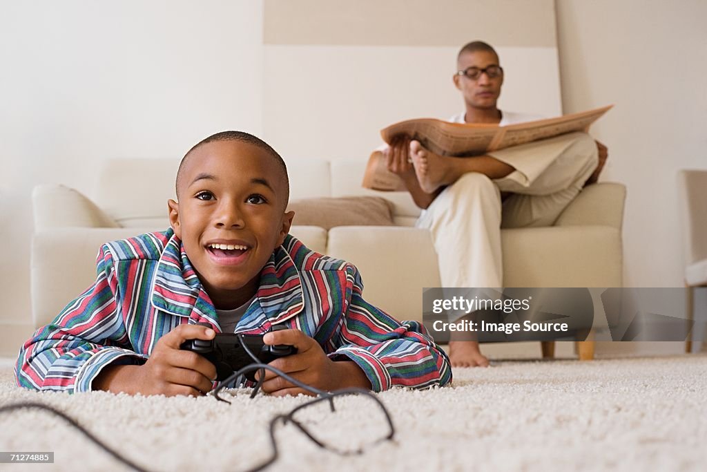 Father and son in lounge, son playing video game
