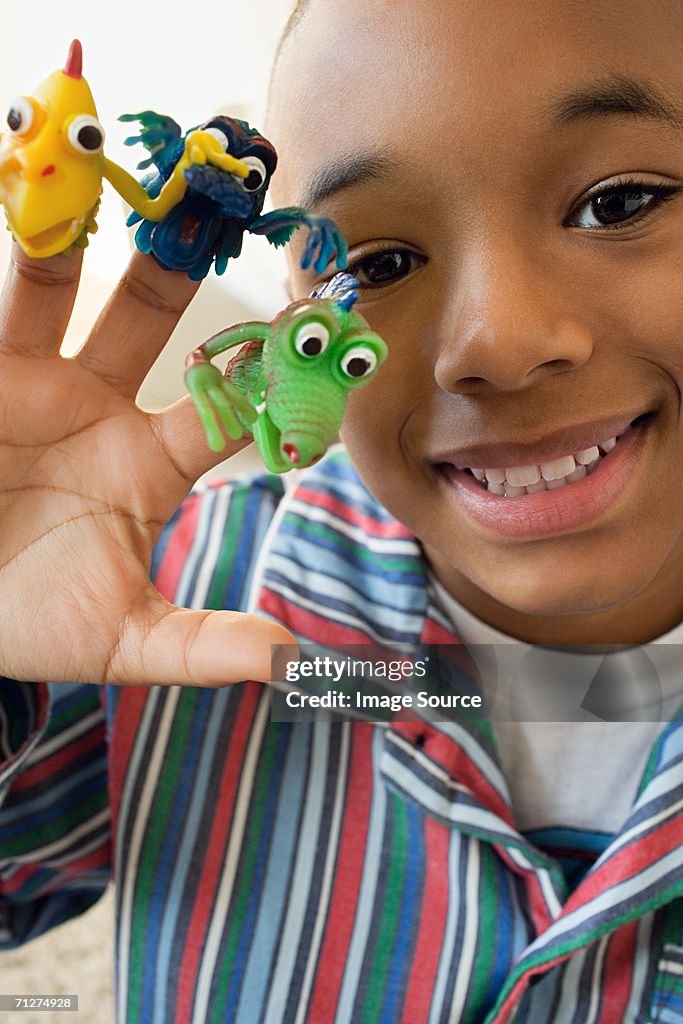 Boy indoors with monster finger puppets on fingers