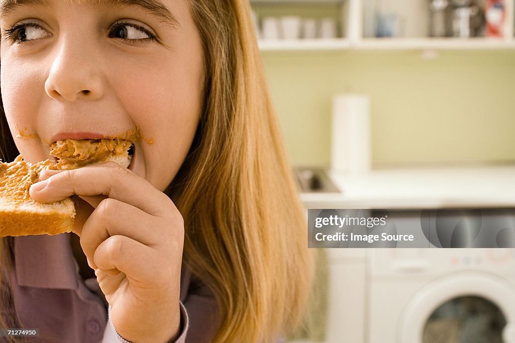 Girl eating toast in kitchen