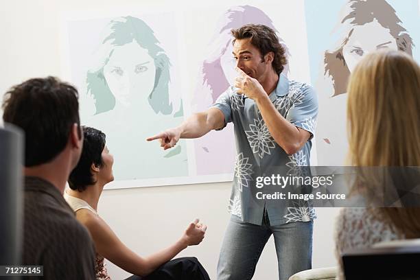 friends playing charades - pantomime stock pictures, royalty-free photos & images