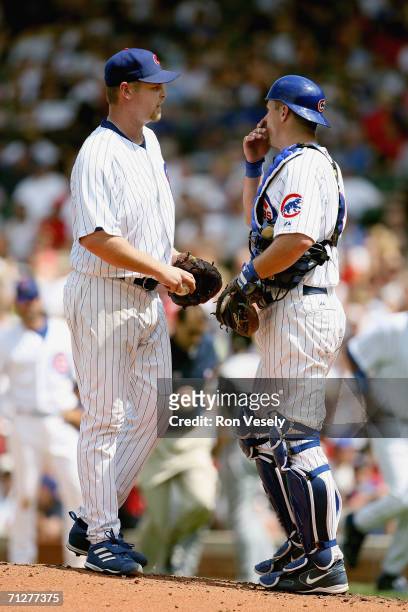 Kerry Wood and Michael Barrett of the Chicago Cubs speak on the mound during the game against the Cincinnati Reds at Wrigley Field in Chicago,...