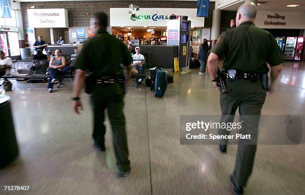Members of the United States Border Patrol check a woman?s nationality at a Greyhound bus station on June 22, 2006 in Phoenix, Arizona. President...