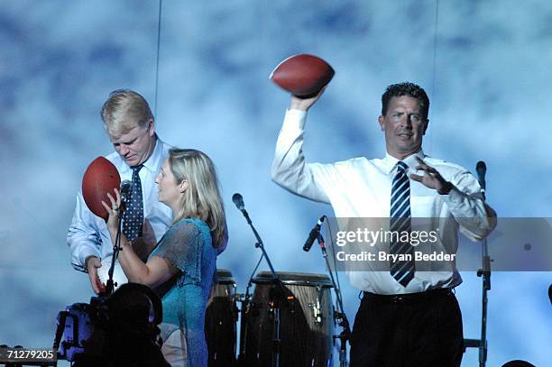 Former NFL quarterbacks Boomer Esiason and Dan Marino appear on stage tossing autographed footballs into the crowd during the Samsung's Four Seasons...