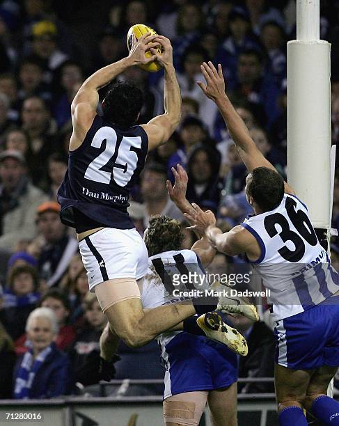 Brendan Fevola of the Blues flies for a mark over Glenn Archer and Shannon Watt of the Kangaroos during the round 12 AFL match between the Kangaroos...
