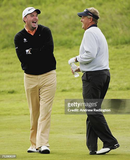 Kenneth Ferrie of England shares a joke with Colin Montgomerie of Scotland on the 18th hole during the second round of The Johnnie Walker...