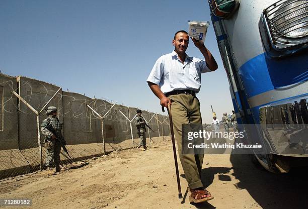 An Iraqi freed prisoner waves as he boards a bus on June 23, 2006 at Abu Ghraib prison west of Baghdad, Iraq. More than 500 Iraqi detainees were...