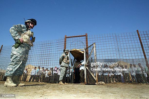 Soldiers stand guard as Iraqi prisoners wait to be released on June 23, 2006 at Abu Ghraib prison west of Baghdad, Iraq. More than 500 Iraqi...