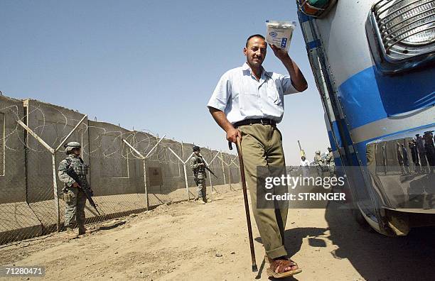An Iraqi freed prisoner waves as he boards a bus 23 June 2006 at Abu Ghraib prison west of Baghdad. Iraq released 500 detainees from the infamous Abu...
