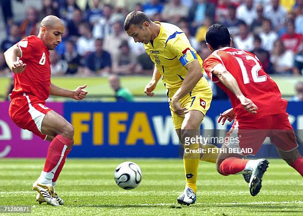Ukrainian forward Andriy Shevchenko is challenged by Tunisian midfielder Medhi Nafti next to Tunisian midfielder Jawhar Mnari in the opening round...