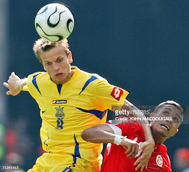 Ukrainian midfielder Oleg Gusev heads the ball in front of Tunisian defender Anis Ayari in the opening round Group H World Cup football match Ukraine...