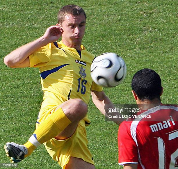 Ukrainian forward Andrei Vorobey controls the ball in front of Tunisian midfielder Jawhar Mnari in the opening round Group H World Cup football match...
