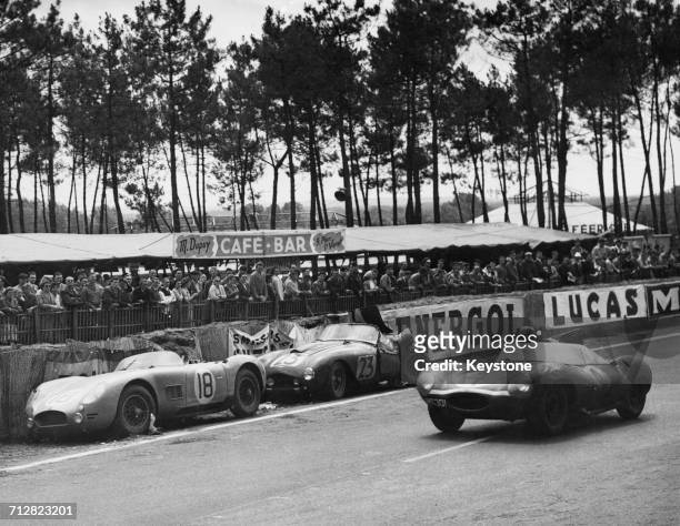 Ninian Sanderson of Great Britain drives the Ecurie Ecosse Jaguar D-Type XKD 501 past the retired Automobiles Talbot Maserati S6 of Jean Lucas and...