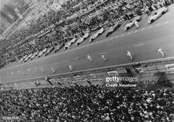 Jacky Ickx of Belgium walks towards his John Wyer Automotive Engineering Ford GT40 MkI in protest at the traditional Le Mans-style running start as...