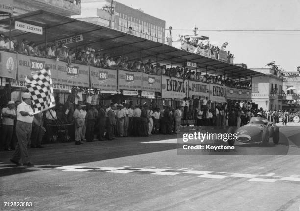 Stirling Moss of Great Britain driving the Vandervell Products Vanwall VW5 takes the chequered flag to win the Pescara Grand Prix on 18 August 1957...