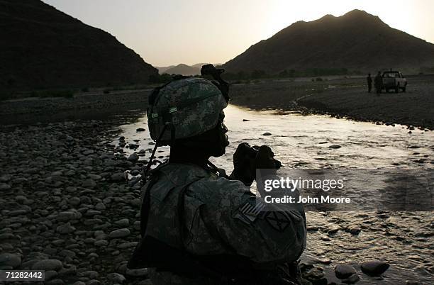 Army Sfc. Lydell Lacy looks toward suspected Taliban positions June 23, 2006 near Deh Afghan in the Zabul province of Afghanistan. Troops from the...