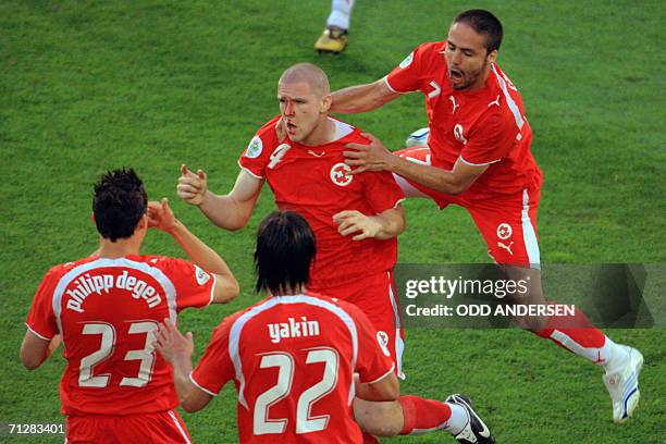 Swiss defender Philippe Senderos is congratulated by teammates defender Philipp Degen and Swiss forward Johan Vonlanthen after scoringa goal during...