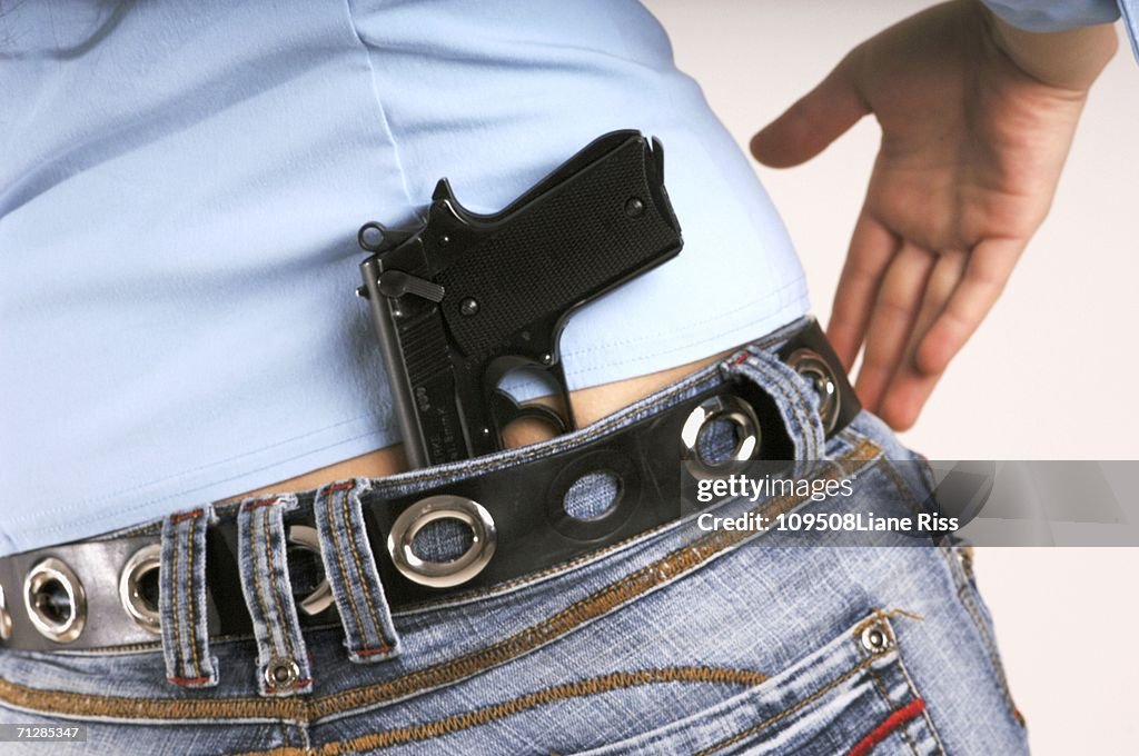 Woman with handgun in jeans