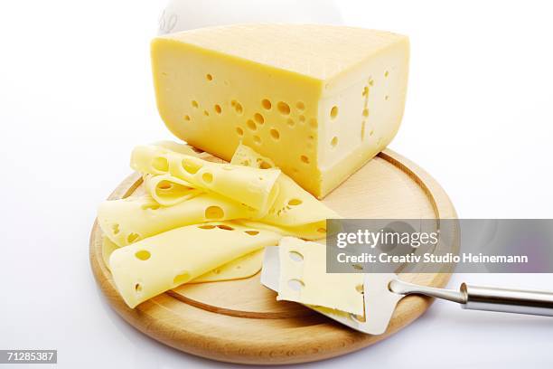 sliced cheese on chopping board - swiss cheese stock pictures, royalty-free photos & images