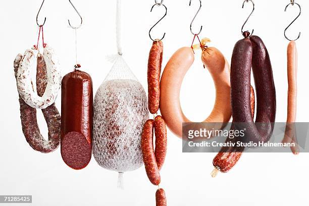 sausages hanging on hooks - metzgerei stock-fotos und bilder
