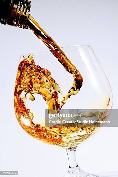 cognac being poured into a glass - cognac fotografías e imágenes de stock