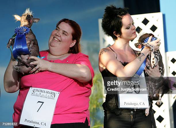 Heather Peoples of Phoenix, Arizona holds her Chinese Crested dog Archie next to a contestant who won ugliest mutt with her dog named Pee Wee during...