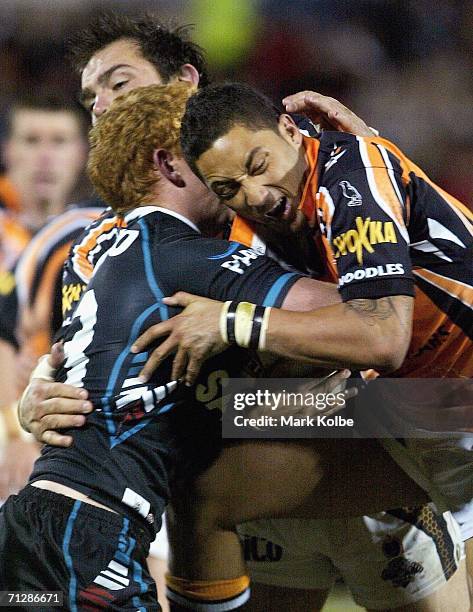 Benji Marshall of the West Tigers grimaces as he makes a tackle during the round 16 NRL match between the Penrith Panthers and the Wests Tigers at...